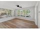 Sunroom with large windows, wood-look floors and ceiling fan at 5425 Waters Edge Dr, New Port Richey, FL 34653