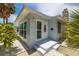 Front view of charming house with white door and landscaping at 850 Mandalay Ave, Clearwater Beach, FL 33767