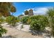 Landscaped yard with tropical plants and stone chimney at 850 Mandalay Ave, Clearwater Beach, FL 33767