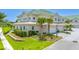 Tan building with green roof, landscaping, and garage at 6 Hibiscus Ln, Belleair, FL 33756