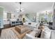 Open concept living room with a white sofa, kitchen view, and large windows at 6 Hibiscus Ln, Belleair, FL 33756