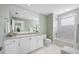 Bathroom boasts white cabinets, marble tile, and bathtub at 6 Hibiscus Ln, Belleair, FL 33756