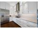 Modern white kitchen with stainless steel appliances and hardwood floors at 6 Hibiscus Ln, Belleair, FL 33756