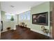 Light-filled hallway with hardwood floors, bench, and artwork at 6 Hibiscus Ln, Belleair, FL 33756