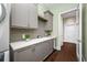 Bright laundry room with built-in cabinets and hardwood floors at 6 Hibiscus Ln, Belleair, FL 33756