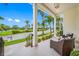 Relaxing front porch with wicker chairs, overlooking a tranquil neighborhood at 6 Hibiscus Ln, Belleair, FL 33756