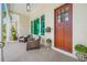 Covered porch features wicker chairs and a view of the neighborhood at 6 Hibiscus Ln, Belleair, FL 33756