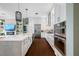 Modern kitchen with white cabinets, stainless steel appliances, and hardwood floors at 6 Hibiscus Ln, Belleair, FL 33756