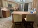 Kitchen with stainless steel appliances, granite countertops, tiled floors, and kitchen island with bar stools at 1964 Arvis E Cir, Clearwater, FL 33764