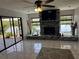 Bright living room featuring a brick fireplace and large glass doors to the outdoor patio overlooking the water at 1964 Arvis E Cir, Clearwater, FL 33764