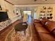 Warm living room with a leather couch, decorative rug, and an open view to the dining area at 1964 Arvis E Cir, Clearwater, FL 33764
