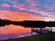 Picturesque waterfront sunset view with a dock extending into the serene water at 1964 Arvis E Cir, Clearwater, FL 33764