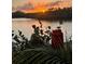 Scenic waterfront view at sunset, with plants and lantern adding charm to the outdoor space at 1964 Arvis E Cir, Clearwater, FL 33764
