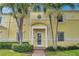 Condo building entrance with yellow facade and lush landscaping at 5257 Beach Se Dr # D, St Petersburg, FL 33705
