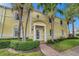Condo building with yellow facade, palm trees, and walkway at 5257 Beach Se Dr # D, St Petersburg, FL 33705