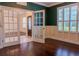 Bright home office with green walls, hardwood floors, and French doors at 7323 Night Heron Dr, Land O Lakes, FL 34637