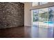 Gathering room with sliding glass doors leading to the pool area and stone accent wall at 7323 Night Heron Dr, Land O Lakes, FL 34637