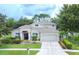 Two-story home with a three car garage and landscaping at 7323 Night Heron Dr, Land O Lakes, FL 34637