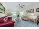 Open living room with a red leather sofa and wicker loveseat, featuring a TV at 1008 Caravel Ct, Tarpon Springs, FL 34689