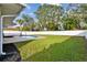 Home features a refreshing pool, expansive grassy yard, and a white vinyl fence at 831 Searcy Ave, Sarasota, FL 34237