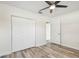 Well-lit bedroom with wood-look floors, ceiling fan, and double door closet at 831 Searcy Ave, Sarasota, FL 34237