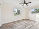 Bright bedroom with wood-look floors, ceiling fan, and large windows at 831 Searcy Ave, Sarasota, FL 34237