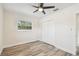 Spacious bedroom featuring wood-look floors, ceiling fan, and double door closet at 831 Searcy Ave, Sarasota, FL 34237