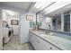 Bathroom with granite countertop, double sink, and laundry area at 50 Coe Rd # 311, Belleair, FL 33756