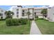 Condo building with manicured landscaping and walkway at 50 Coe Rd # 311, Belleair, FL 33756