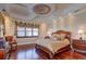 Spacious main bedroom with hardwood floors, large windows, and ornate furniture at 1227 Osowaw Blvd, Spring Hill, FL 34607