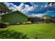 Lush green backyard with mature landscaping and a view of the screened lanai perfect for entertaining at 10799 Harborside Dr, Largo, FL 33773