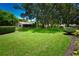 Lush green backyard showcasing mature trees and manicured landscaping, offering a private outdoor space at 10799 Harborside Dr, Largo, FL 33773