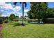 Expansive backyard featuring a tranquil pond, lush lawn, and mature trees, offering serene outdoor living at 10799 Harborside Dr, Largo, FL 33773