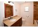 Well-lit bathroom featuring granite countertops, dark wood vanity, tile floors, and decorative fixtures at 10799 Harborside Dr, Largo, FL 33773
