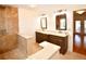 Bright bathroom features dual sink vanity, tiled shower, and an open doorway to a living area at 10799 Harborside Dr, Largo, FL 33773
