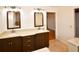 Bright bathroom with a double vanity, dark wood cabinetry, tile floor, and access to a doorway at 10799 Harborside Dr, Largo, FL 33773
