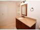Well-lit bathroom featuring granite countertops, dark wood vanity, tile floors, and decorative fixtures at 10799 Harborside Dr, Largo, FL 33773