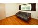 Bedroom showcasing hardwood floors and a futon with a window and wood shutters at 10799 Harborside Dr, Largo, FL 33773
