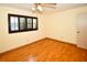 Bedroom featuring hardwood floors, a ceiling fan, and a window with dark wood shutters at 10799 Harborside Dr, Largo, FL 33773