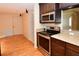 Kitchen with stainless steel appliances, granite countertops, dark wood cabinets and drawers, and hardwood floors at 10799 Harborside Dr, Largo, FL 33773