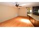 Open living room featuring hardwood floors, ceiling fan, and natural light coming from an adjacent kitchen area at 10799 Harborside Dr, Largo, FL 33773