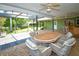 Spacious covered patio includes a dining set, a bar, and views of the backyard at 10799 Harborside Dr, Largo, FL 33773