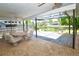 Covered outdoor patio with a dining set and a view of the lush backyard at 10799 Harborside Dr, Largo, FL 33773