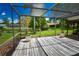 Tranquil screened patio with wood flooring overlooks a pond and a well-manicured lawn at 10799 Harborside Dr, Largo, FL 33773