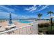 Resort-style pool deck with lounge chairs and Gulf views under a sunny, partly cloudy sky at 6177 Sun Blvd # 108, St Petersburg, FL 33715