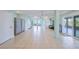 Open basement with tile floors, two refrigerators and a sliding door leading to an outdoor space at 644 Bayshore Dr, Tarpon Springs, FL 34689