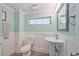 Half bath featuring wainscotting, pedestal sink, and modern fixtures at 644 Bayshore Dr, Tarpon Springs, FL 34689