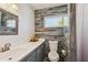 This bathroom features wood style tile walls, large mirror, flowers, and a window at 644 Bayshore Dr, Tarpon Springs, FL 34689