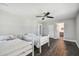 A naturally lit bedroom with hardwood floors and ceiling fan, featuring twin beds and ensuite access at 644 Bayshore Dr, Tarpon Springs, FL 34689