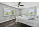 This bedroom features two twin beds, ceiling fan, dark floors, and a window letting in lots of natural light at 644 Bayshore Dr, Tarpon Springs, FL 34689